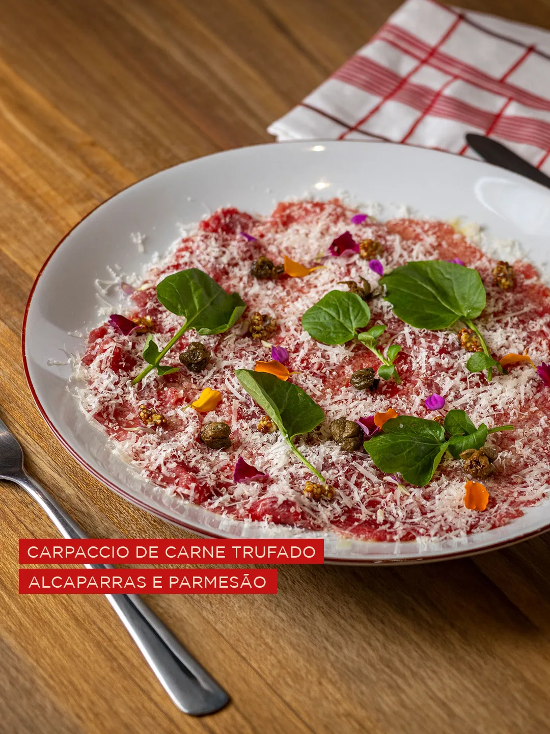 Carpaccio de carne trufada com alcaparras, agrião e parmesão